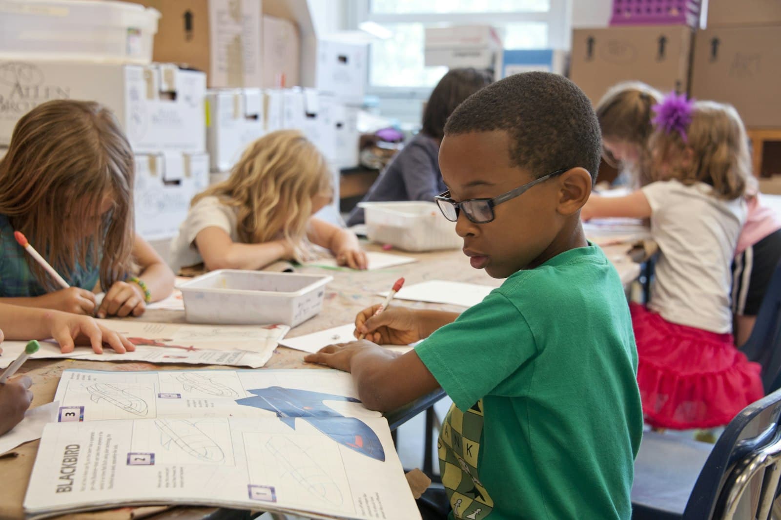 Elementary students writing at their desks in a classroom
